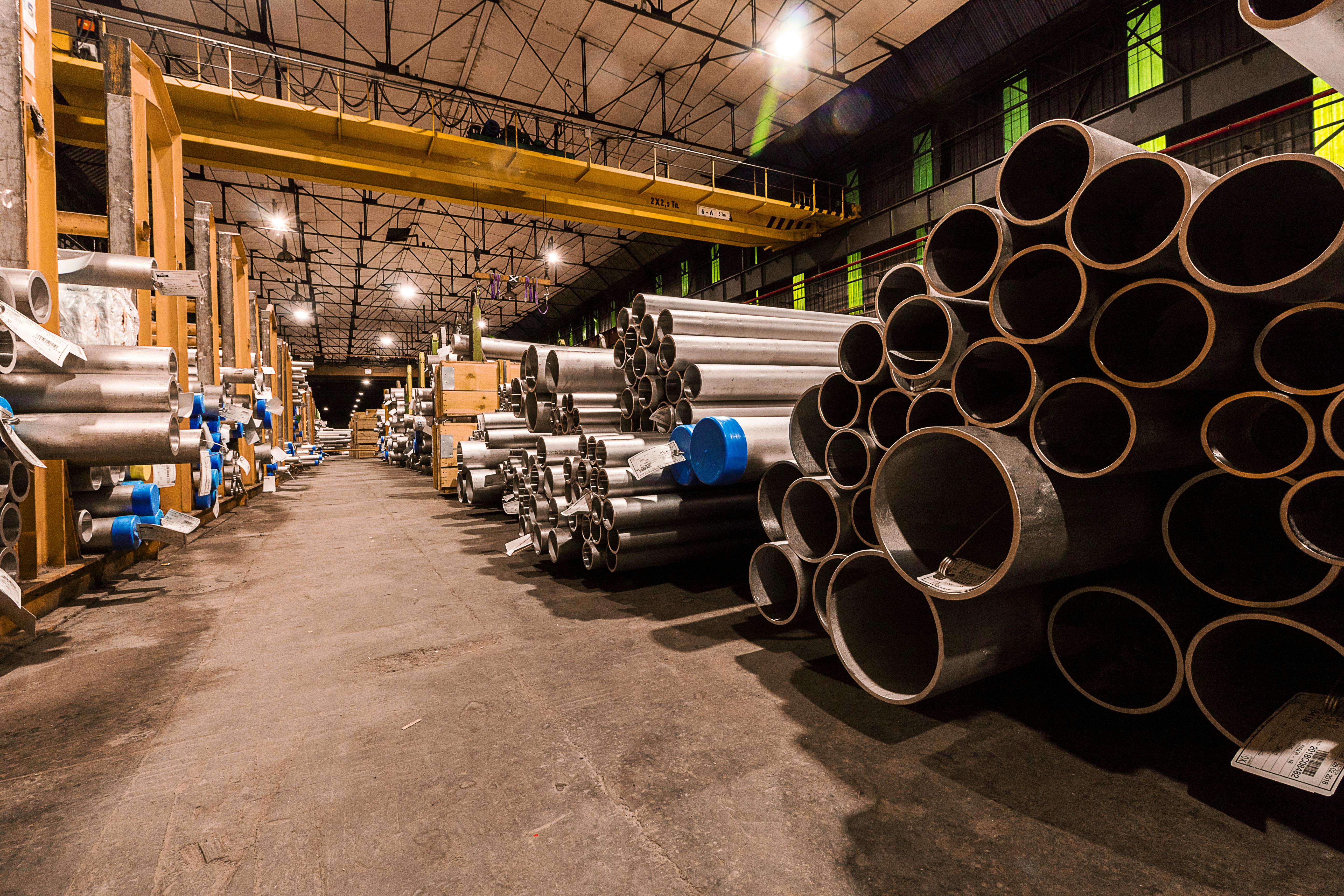 IBR seamless steel pipes stacked in warehouse with overhead crane, Mumbai stockist